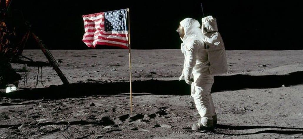 un homme sur la lune à côté du drapeau américain